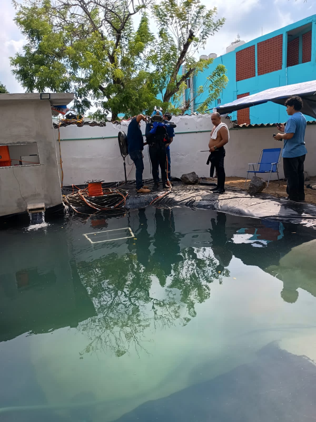 Equipo de apoyo asistiendo a un buzo con casco antes de la inmersión