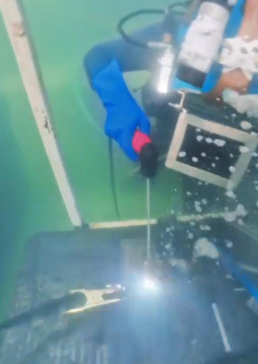 Buzo soldador realizando soldadura submarina con electrodo bajo el agua